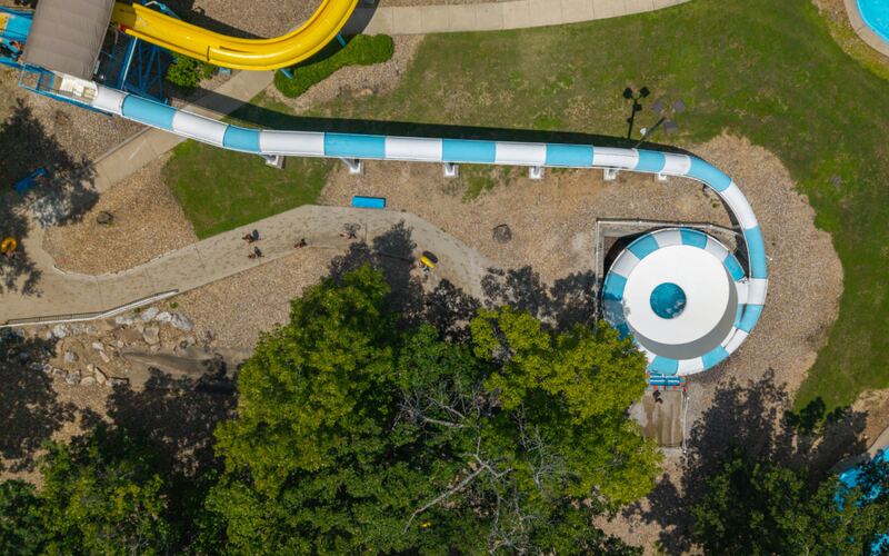 Aerial view of the teal and white Space Bowl water slide tube curving into a spinning bowl